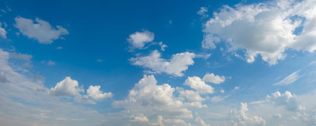 The sky is blue with a few clouds scattered throughout. The clouds are white and fluffy, giving the...