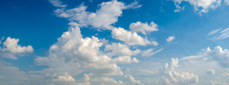 The sky is blue with a few clouds scattered throughout. The clouds are white and fluffy, giving the...