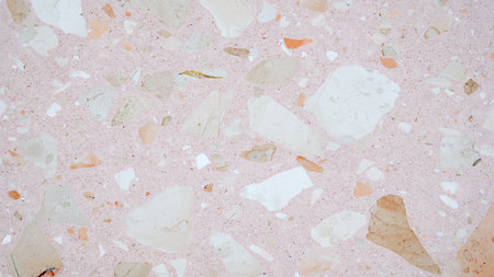 A pink and white stone wall with a lot of small rocks. The wall is very textured and has a lot of detailの写真素材