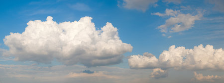The sky is blue with a few clouds scattered throughout. The clouds are white and fluffy, giving the...