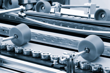 Part of a modern roller conveyor with metal and plastic rollers for the production of various products, industrial concept background.の写真素材