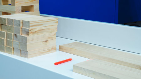 A white counter top with a stack of wooden blocks on it. The blocks are of different sizes and are...