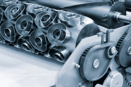 A machine with a large metal cylinder on it. The cylinder is silver and has a lot of holes in itの写真素材