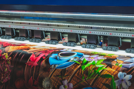 A large printer is printing a colorful image of a coffee cup and flowers. The image is vibrant and...
