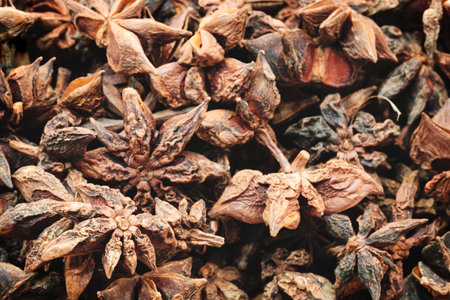A close up of a bunch of dried up star anise. The spice is brown and has a strong aroma
