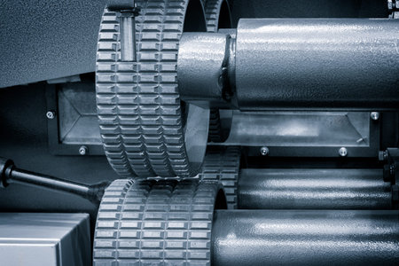 A machine with many wheels and a black color. The wheels are made of metal and are connected to each...