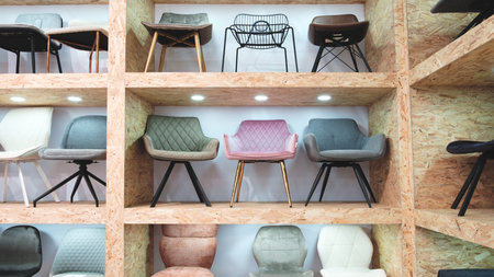 A row of wooden shelves with a variety of chairs on them. The chairs are of different colors and...