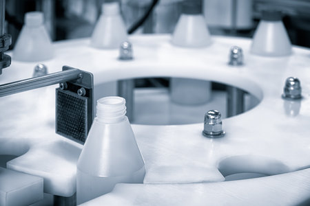 A white plastic bottle with a label on it. The bottle is sitting on a white surface. There are other bottles in the backgroundの写真素材