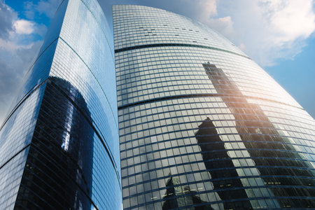 A tall building with a large glass window. The building is in the city. The sky is blueの写真素材