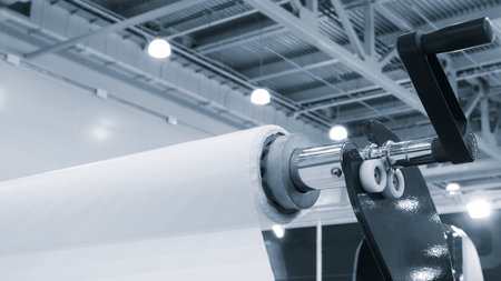 Automatic polyethylene plastic bag production machine with lighting effect. Close-up of the roller of the plastic bag production machine in the light blue scene. product packagingの写真素材