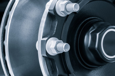 The wheel is black and silver with a white rim and is secured with large bolts and nuts. The wheel...