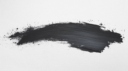 A black brush stroke on a white background. The brush stroke is thick and bold, creating a sense of movement and energy. The black color of the brush stroke contrasts with the white backgroundの写真素材