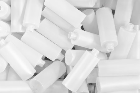 A pile of white plastic bottles with the tops removed as a textured background. Industrial concept background.の写真素材