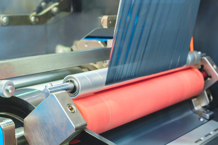 Automatic polyethylene plastic bag production machine with lighting effect. Close-up of the roller of the plastic bag production machine in the light blue scene. product packaging conceptの写真素材