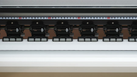 A printer with a ruler on it. The ruler is black and white and has numbers on it