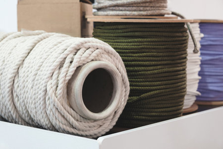 A white and green rope is placed on top of a white box. The white rope is wrapped around the green rope, creating a visually appealing and colorful displayの写真素材