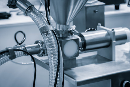 A machine with a white tube attached to it. The tube is connected to a machine that is making somethingの写真素材