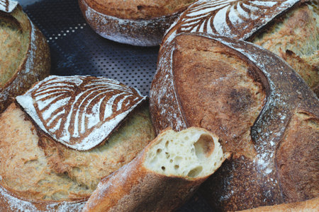 A display of bread with a variety of shapes and sizes. The bread is arranged on shelves and is ready...