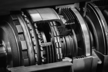 A dark black close up of a machine with many gears and discs. concept of powerful industrial energy of complexity and intricacy, and a sense of awareness at engineering behind machine.の写真素材