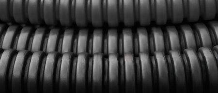 Dark black close up of corrugated industrial plastic pipes as industrial concept background