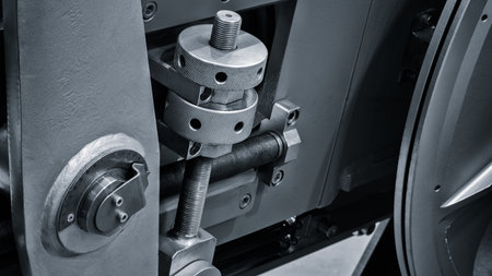 A machine with a metal part that has a bolt on it. The bolt is in the middle of the machine and is...