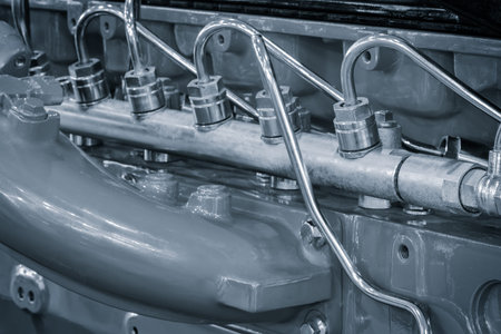 A close up of a car engine with a lot of pipes coming out of it. The pipes are silver and the engine...