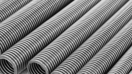 Row of stainless steel corrugated high pressure pipes in silver color. The pipes are long and thin. Mechanical industrial concept backgroundの写真素材