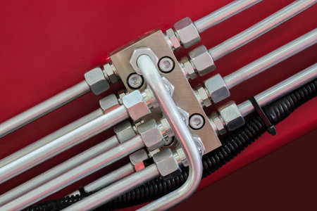 bunch of pipes are connected to each other. pipes are silver and have many nuts and bolts, as part...