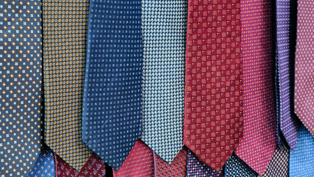 Row of ties with different patterns and colors. ties are hanging on a wall. Concept of variety and choice, as different patternsの写真素材