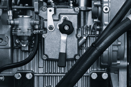 Close up of a car engine with a black hose attached to it. The hose is connected to a black valve in...