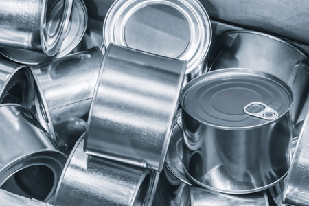 Box full of metal cans as background food production concept.