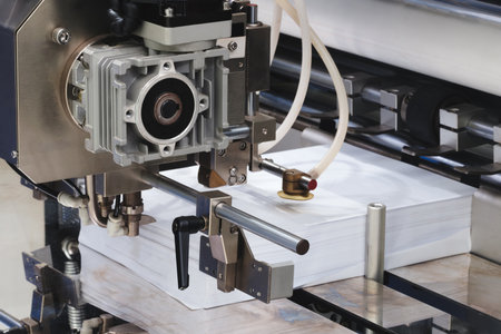 Elements of cardboard boxes are collected in stack. Conveyor line for the production of boxes. Machine cuts cardboard boxes from sheets of cardboard. Enterprise for production package.の写真素材