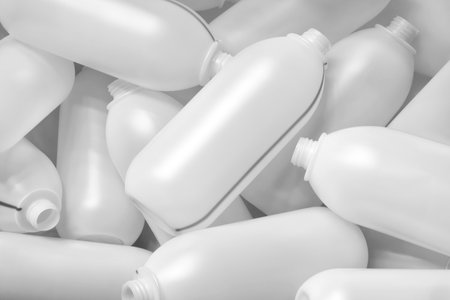 White plastic bottles made by extrusion method lie as textured industrial background for web banner page template.の写真素材