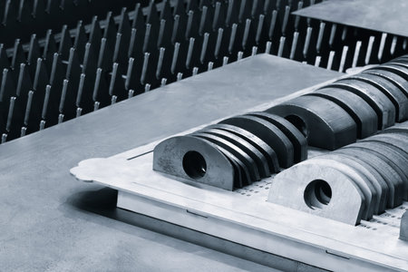 Metal plates with holes on industrial machine in factory, industrial concept background
