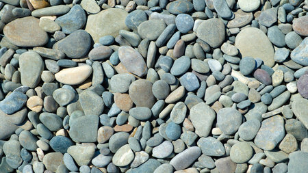 Pebbles stones on seashore as texture background for design of web banner template page. many stones...