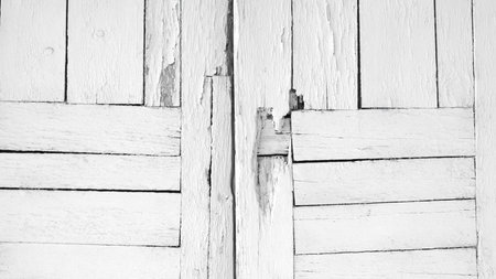 white door with a wooden frame. door is open and has a few holes in it. Scene is somewhat eerie and unsettling, as the door appears to be in disrepairの写真素材