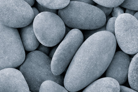 Pebbles stones on seashore as texture background for design of web banner template page. dry stones illuminated by sunの写真素材