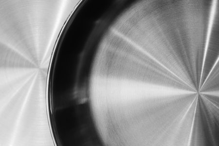 Silver frying pan with black rim. The frying pan is shiny and has a smooth surface as an abstract metallic texture background for web banner template page designの写真素材