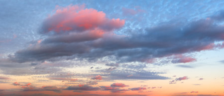 A wide panorama of a beautiful pink and blue sunset sky with clouds. The sky in pink and blue tones...