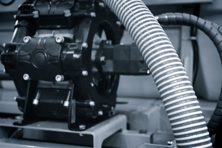 A hose is attached to a black machine. The hose is wrapped around the machine