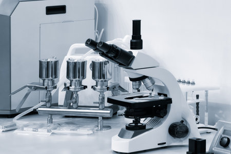A microscope sits on a table among several other objects in a chemical biology laboratory.の写真素材