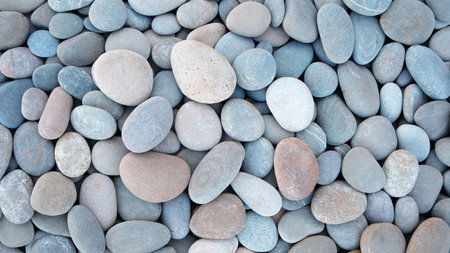 Pebbles stones on seashore as texture background for design of web banner template page. many stones...