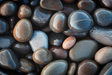 A collection of wet, smooth, multicolored sea stones. The concept of tranquility and serenity serves...