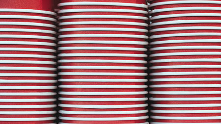 Red paper cups are stacked and ready to be used for selling juice, water, coffee or other fast food...