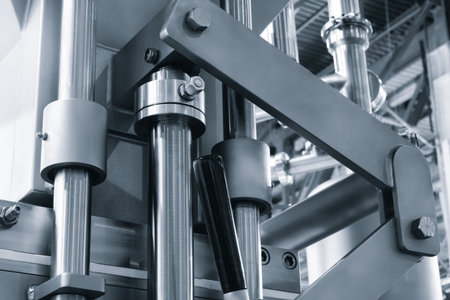 Industrial medicine production machine in pharmaceutical factory with many shiny stainless steel...