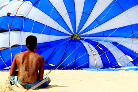 Drying and preparation of parachute on sandy beachの写真素材