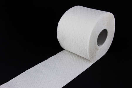 White toilet paper roll isolated on black backgroundの写真素材