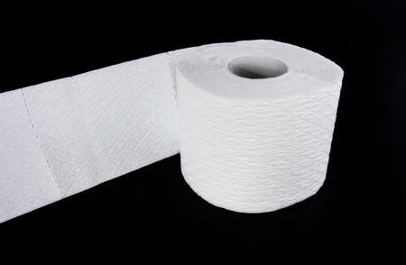 White toilet paper roll isolated on black backgroundの写真素材