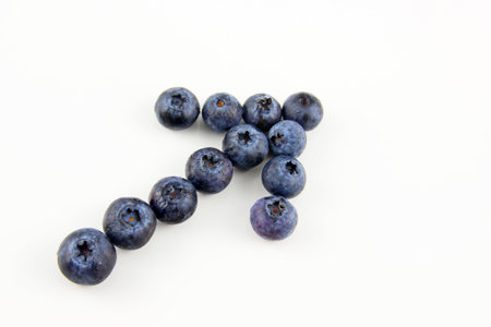 Fresh blueberries in a shape of an arrow isolated on white background