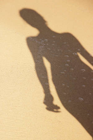 Woman s silhouette on sandの写真素材